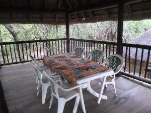 - une table et des chaises sur une terrasse couverte avec une moustiquaire et une table et des chaises dans l'établissement Marloth Havens, à Malelane