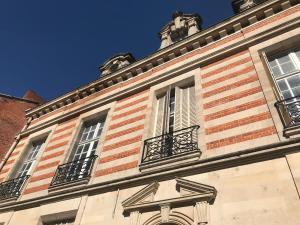 - un bâtiment avec des fenêtres et des balcons au-dessus dans l'établissement Le Jardin d'Hiver, à Châlons-en-Champagne