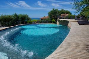 een zwembad met blauw water in een tuin bij Résidence Cantu di Mare in Olmeto