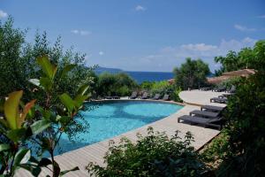 a swimming pool with lounge chairs and the ocean in the background at Résidence Cantu di Mare in Olmeto