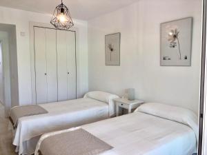 Habitación hospitalaria con 2 camas y espejo en Apartamento Guadalmina - Golf & Playa - Marbella, en Marbella
