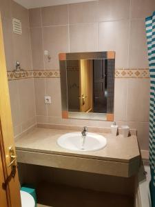 een badkamer met een wastafel en een spiegel bij Encosta da Marina Residence in Portimão