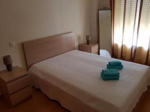 een slaapkamer met een bed met twee handdoeken erop bij Encosta da Marina Residence in Portimão