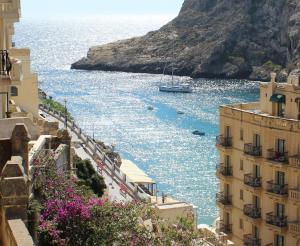 a view of the ocean from between two buildings at Serenity - Bellevue Gozo in Xlendi