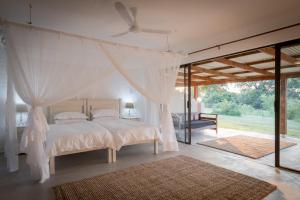 a bedroom with a bed with a canopy at Makuwa Safari Lodge in Mbabat