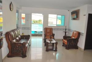 een wachtkamer met stoelen en een tafel en een klok bij Hotel Diamante Real Cienaga in Ciénaga