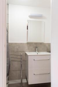 ein Badezimmer mit einem Waschbecken und einem weißen Schrank in der Unterkunft Place du Pin in Nizza