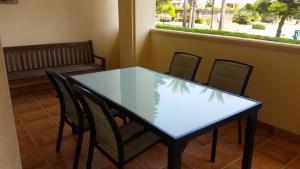 ロケタス・デ・マルにあるApartamento Villa Romana Playaの窓付きの客室で、ガラスのテーブルと椅子が備わります。