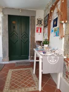 a room with a green door and a table in front of it at carugio del fezzano in Fezzano
