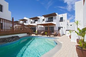 a villa with a swimming pool in front of a house at Casa Hibiscus in Punta de Mujeres