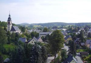una pequeña ciudad con una iglesia y una ciudad con árboles en Ferienwohnung Kaufmann, en Sehma