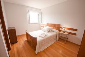 a small bedroom with a bed and a window at As Viñas in Viveiro
