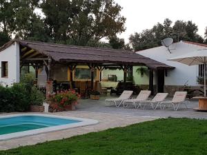 une terrasse avec des chaises, une piscine et une maison dans l'établissement Casa Rural Vega el Dorado, à San Pablo