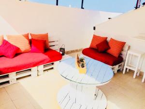 a living room with two red couches and a glass table at Appartamento La Terrazza in Castellammare del Golfo