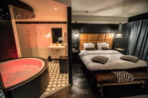 埃德Hotel ReeHorst的一间带浴缸和床的卧室以及一间浴室。