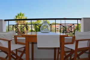 a table and four chairs on a balcony at Fokais Beach Apartment in Nea Fokea