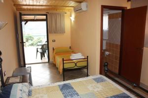a bedroom with two beds and a table and a window at Agriturismo Ghiritina in Francavilla di Sicilia