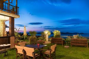 a patio with a table and chairs with a view of the ocean at Archontiko Zakoni in Neochori