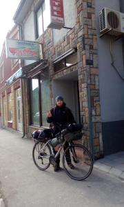 a man standing next to a bike in a building at Hostel Olimpik in Negotin