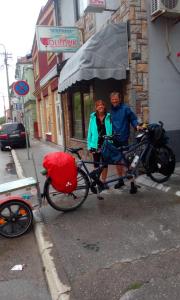 dwoje ludzi stojących obok roweru z parasolką w obiekcie Hostel Olimpik w mieście Negotin