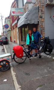 dos personas de pie junto a una bicicleta con un paraguas en Hostel Olimpik, en Negotin