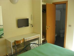 Habitación con escritorio y TV en la pared. en Hotel Esperia, en Sammichele di Bari