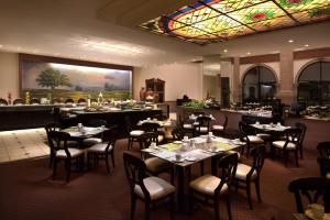 a restaurant with tables and chairs and a stained glass ceiling at Krystal Monterrey in Monterrey