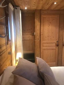 a bedroom with a bed and a wooden door at Chez Fred et Carine (Petit-déjeuner bio inclus) in Auron