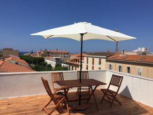 un tavolo e sedie su un balcone con ombrellone di VIAXX 51 ad Alghero