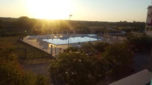 a large swimming pool with the sun in the background at appartamento Lory in Campomarino +5 photos