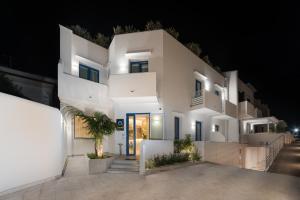 een groot wit gebouw 's nachts met verlichting bij Hermes Hotel in San Vito lo Capo