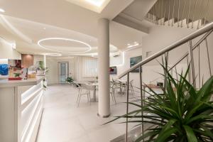 a living room with a staircase and a dining room at Hermes Hotel in San Vito lo Capo