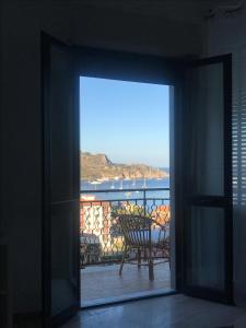 una porta aperta su un balcone con vista sull'oceano di Baia Taormina Apartment a Giardini Naxos