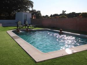 a swimming pool with two people in the water at Pilar Casa Rural in Trujillo