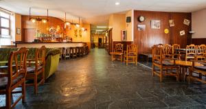 a restaurant with wooden chairs and tables and a bar at Hotel Hipic in Vielha