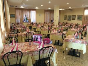 貝拉里亞－伊賈馬里納的住宿－Hotel Adriana，一间摆放着桌椅的粉红色桌布客房