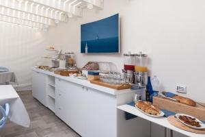 a kitchen with a counter with pastries and bread at Hermes Hotel in San Vito lo Capo