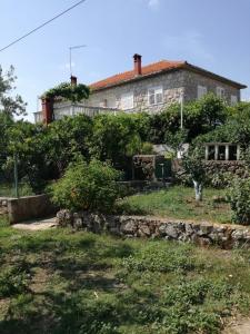 a house with a stone wall in front of it at Apartman Stipe in Jelsa