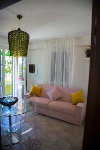 un soggiorno con divano e tavolo in vetro di Le Suites del Carrubo a Favignana