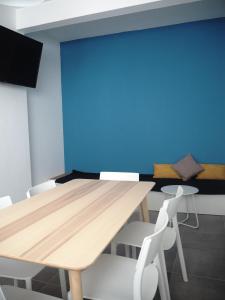 ラゴスにあるCasa AUGUSTAの青い壁の客室で、テーブルと椅子が備わります。