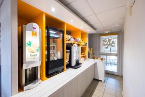 a coffee shop with a drink dispenser on a counter at Premiere Classe Toulon La Seyne-sur-Mer in La Seyne-sur-Mer