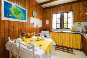 a kitchen with a table and a sink in a room at La Kaz à Mélina in Le Tampon