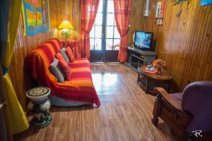 a living room with a couch and a television at La Kaz à Mélina in Le Tampon