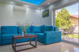 a blue couch in a living room with a table at GardenLux Vrdnik in Vrdnik