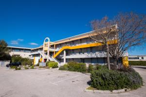 ein Bürogebäude mit einem gelben und weißen Gebäude in der Unterkunft Premiere Classe Toulon La Seyne-sur-Mer in La Seyne-sur-Mer