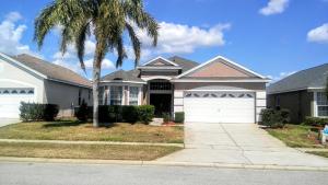 a house with a palm tree in front of it at Kissimmee Area Pool Home in Orlando