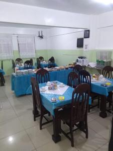 a room with blue tables and chairs with food on them at Epílogo Palace Hotel in Rio Branco