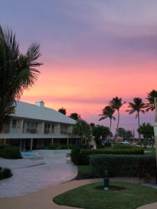 a sunset view of a resort with palm trees at GetAways at Dover House Resort in Delray Beach