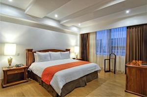 サンホセにあるBalmoral Hotel San José CR, Historic Districtのベッドと大きな窓が備わるホテルルームです。