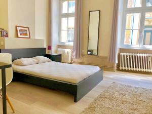 1 dormitorio con 1 cama en una habitación con ventanas en Urban apartment, in the nightlife area!, en Luxemburgo